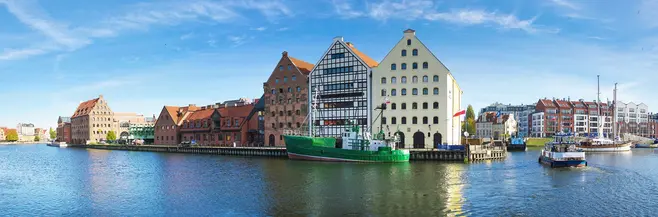 Gdańsk - Wyspa Spichrzów - na pierwszym planie rzeka Motława, w oddali stare budynki